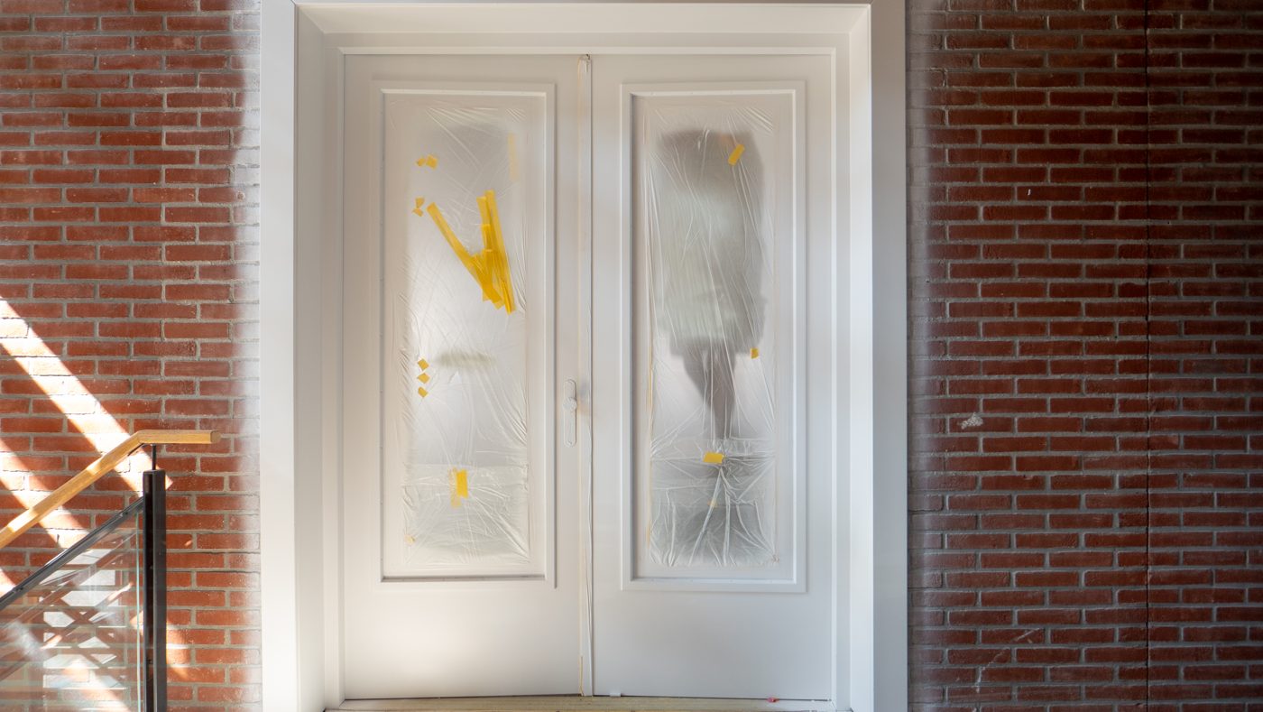 Freshly painted double doors, taped and protected, at Pulse